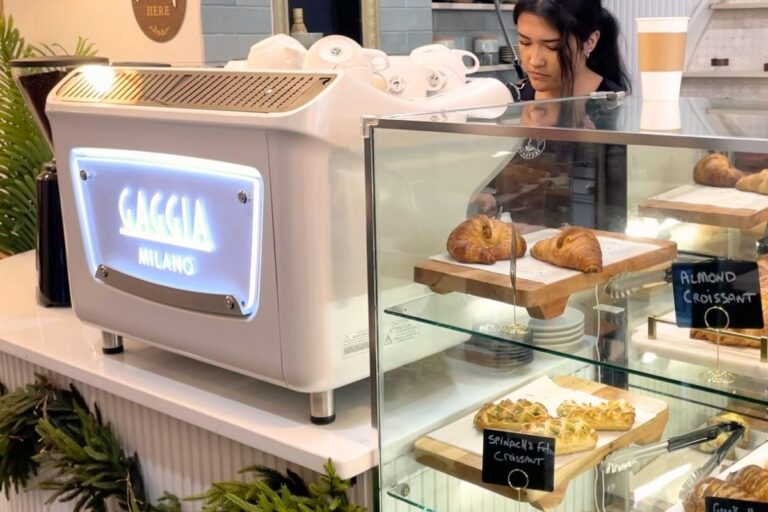 View of barista preparing a drink behind the chic Gaggia espresso machine on the counter at Coffeefi Roastery in Bethesda