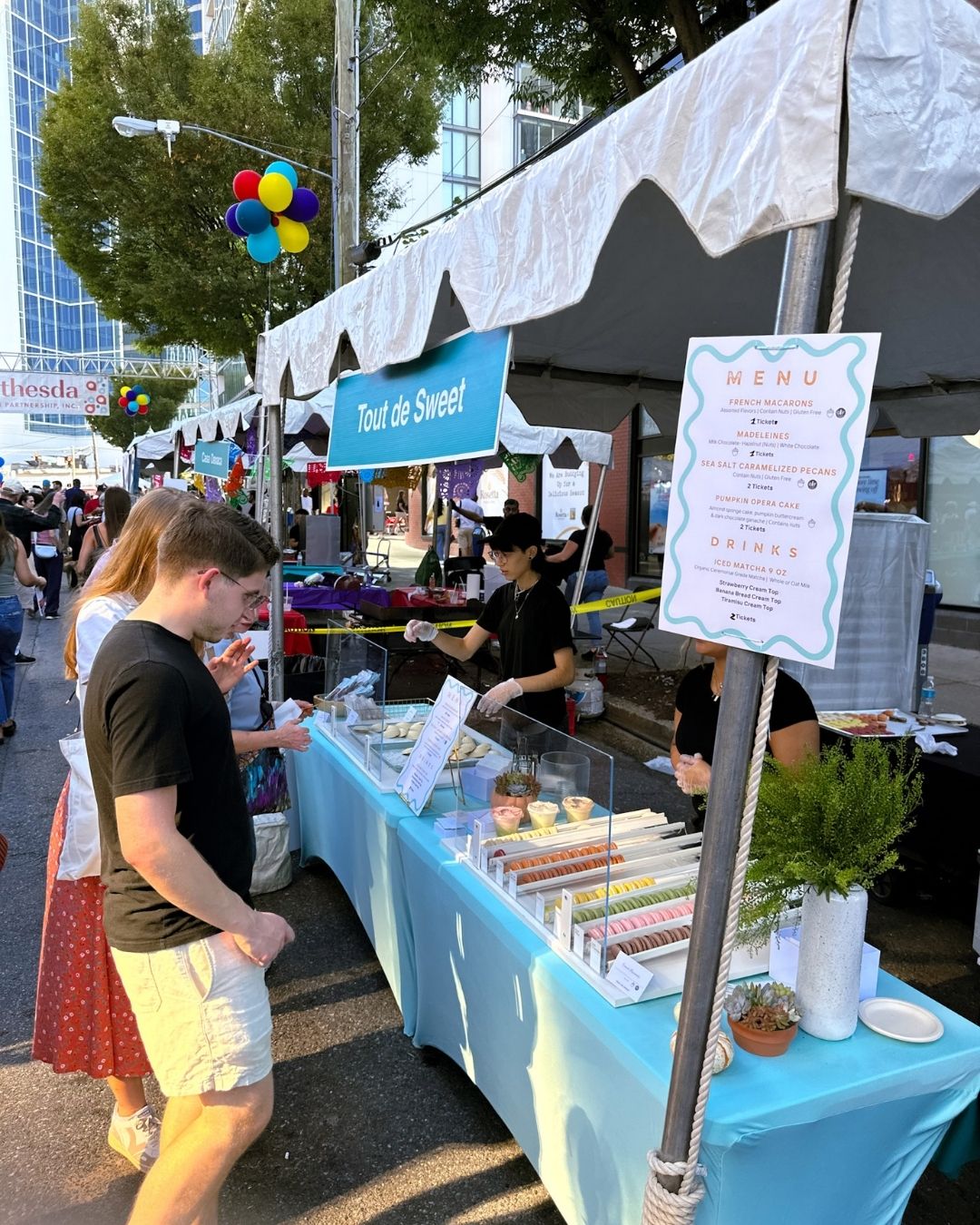 Customers at Tout de Sweet dessert booth that served colorful macarons
