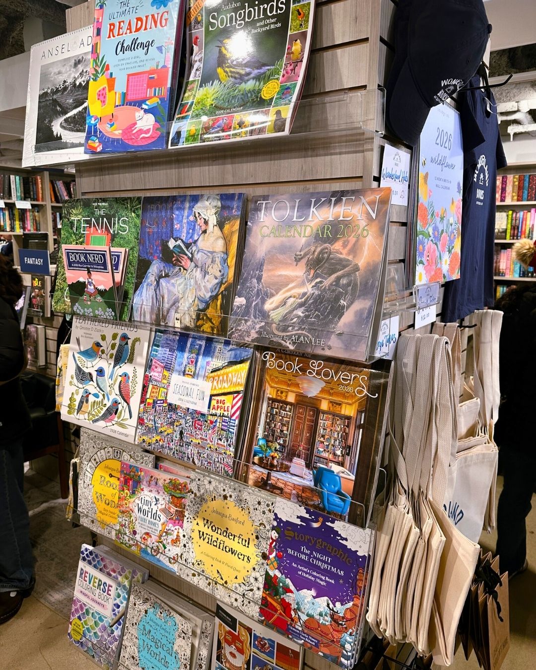 Gift display with coloring books, calendars, and tote bags at Wonderland Books