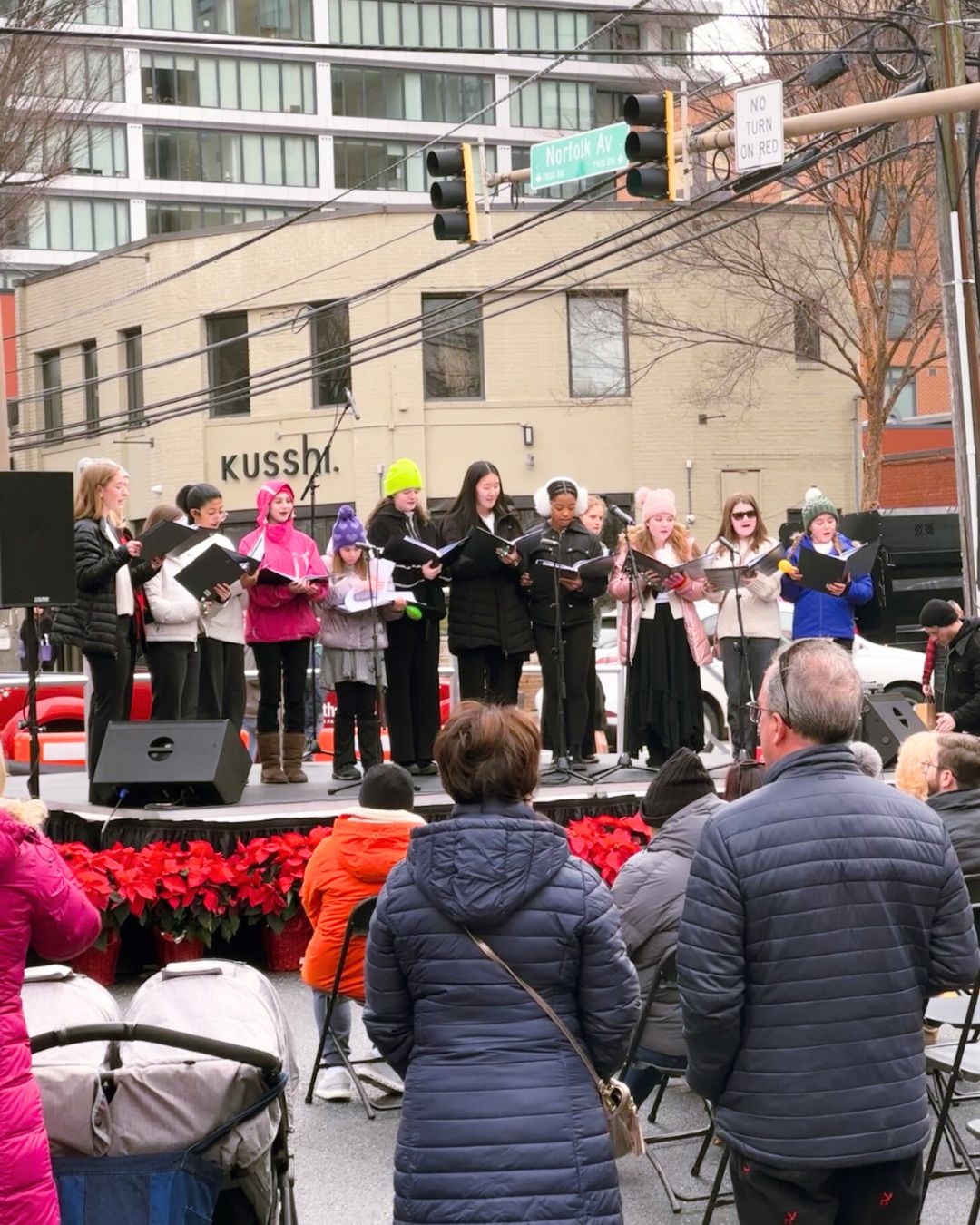 Youth choir singing on outdoor stage at Norfolk Avenue intersection.
