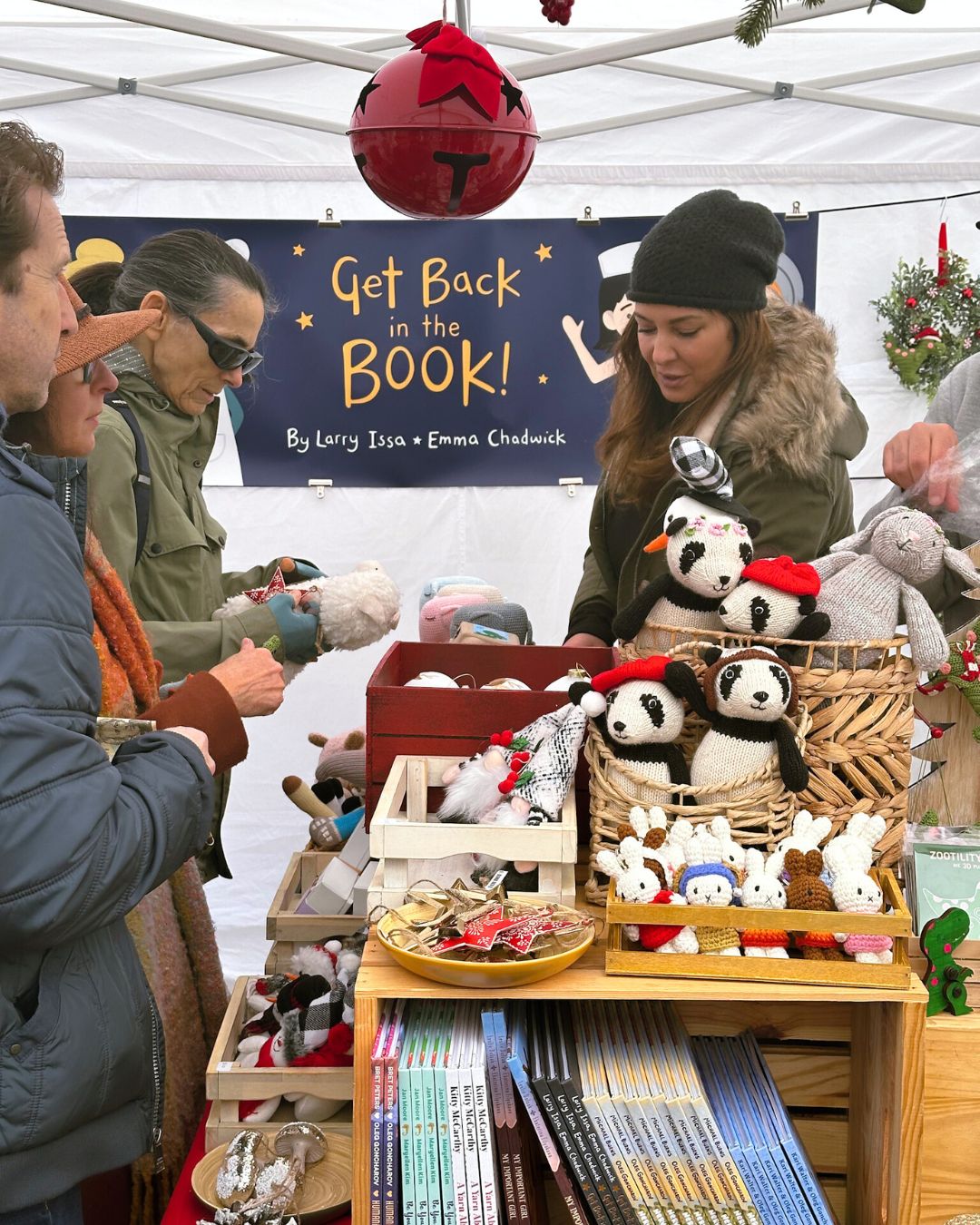 Shoppers browsing and in line to buy knit toys at the "Get Back in the Book!" booth.