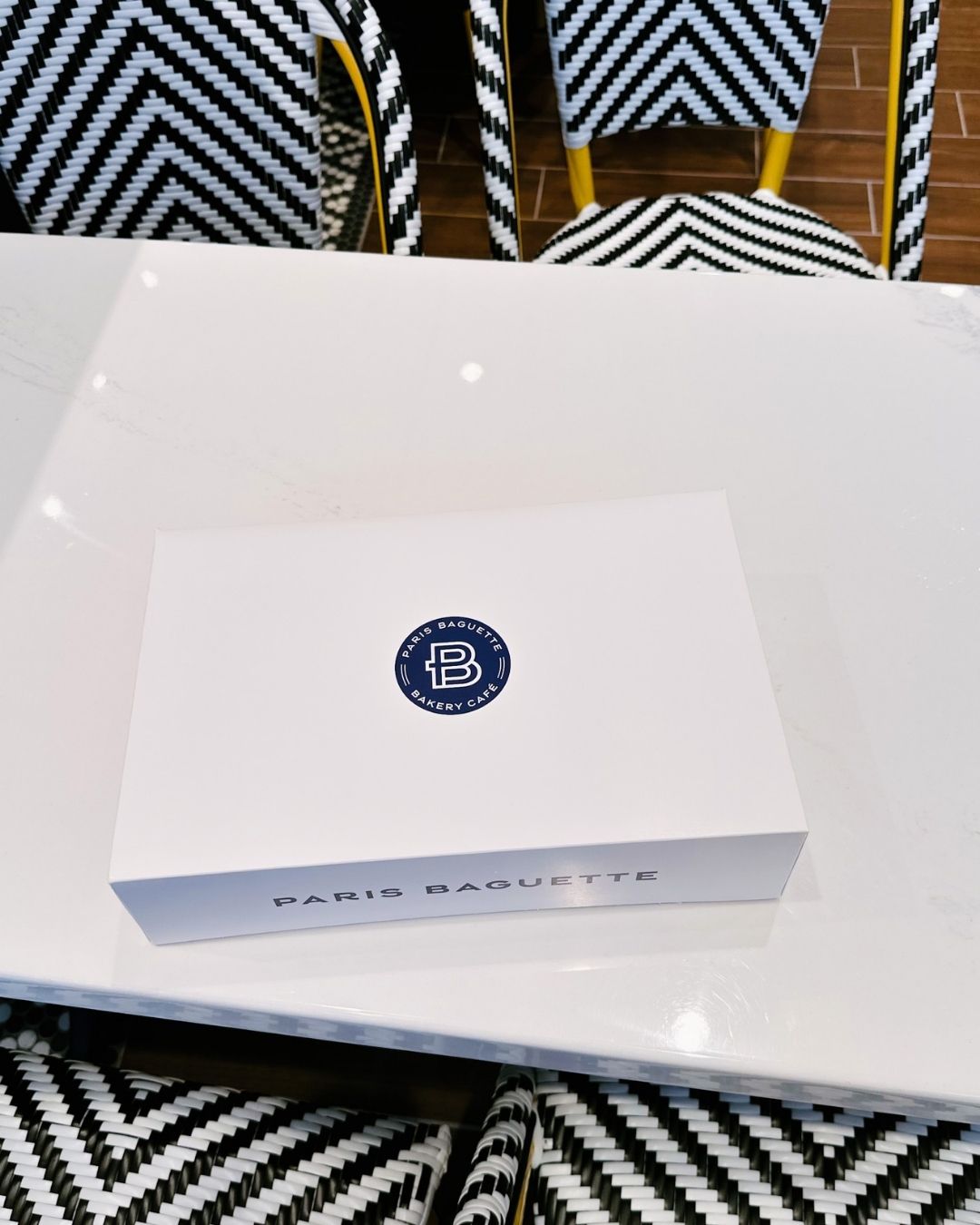 White Paris Baguette branded pastry box on cafe table in Bethesda