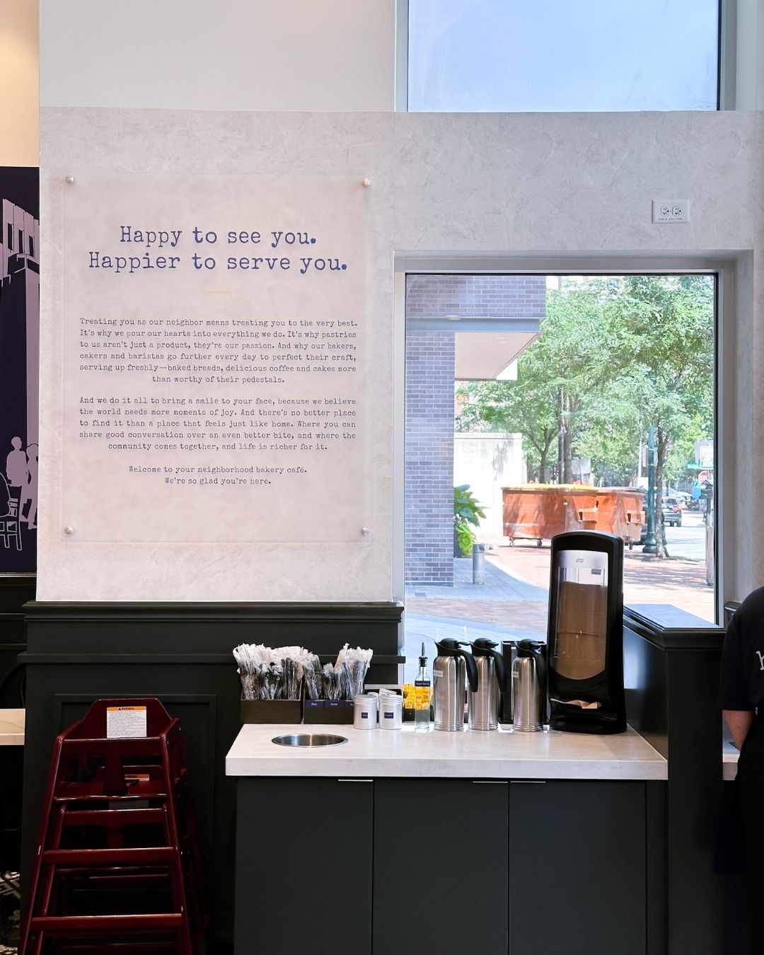 "Happy to see you. Happier to serve you." + a mission statement wall at Paris Baguette Bethesda with window view