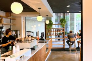 Interior of Simona Cafe in Bethesda with espresso bar, globe pendant lights, and retail coffee bags on wooden shelving